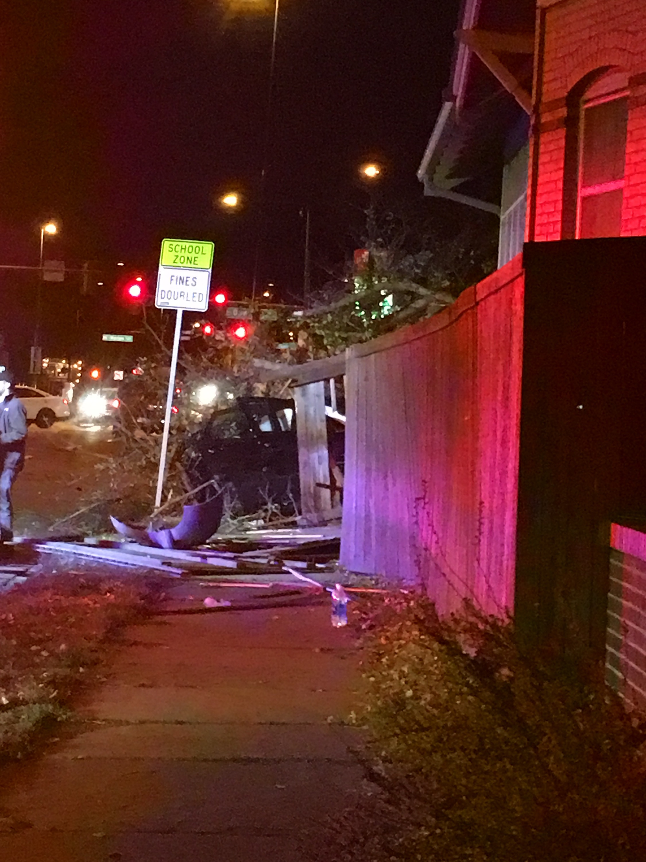 Car crashed through fence viewed from sidewalk
